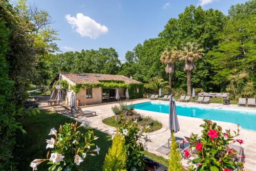 une cour accueillante avec une piscine et une maison dans l'établissement Le Moulin Haut Gîtes, à Villeneuvette