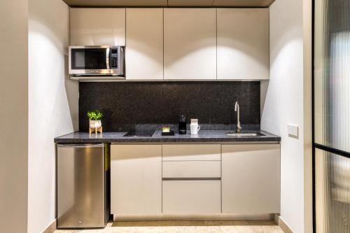 a kitchen with white cabinets and a counter top at UTOPIC Platon by ULIV in Mexico City