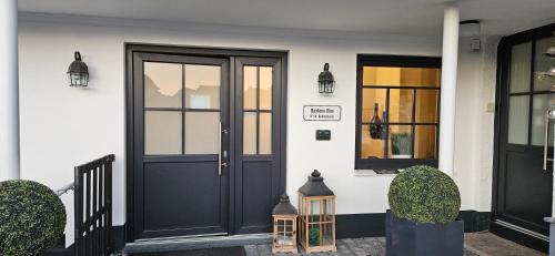 a house with a black door and two windows at Haylees Hus in Kellenhusen