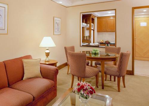 a living room with a couch and a table and chairs at Richmonde Hotel Ortigas, Manila in Manila