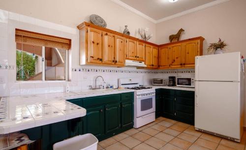 Una cocina con gabinetes verdes y un refrigerador blanco. en Casa Susie San Felipe Rental Home with Garage, en Playa Unión
