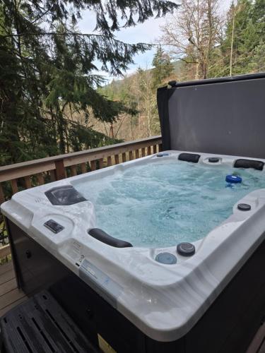 a large hot tub sitting on a deck at Dovetail Den - Tranquil with Hot Tub and Air Conditioning in Ashford