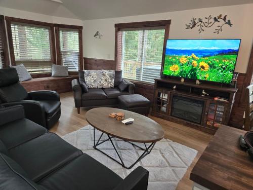 a living room with a tv and a couch and a table at Dovetail Den - Tranquil with Hot Tub and Air Conditioning in Ashford