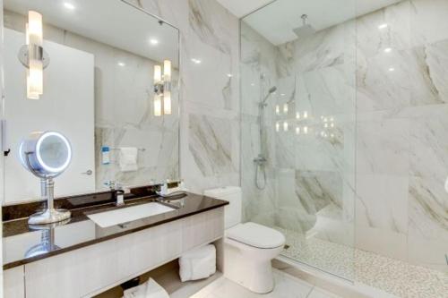 a bathroom with a sink and a shower and a toilet at Hotel Port-Royal in Quebec City