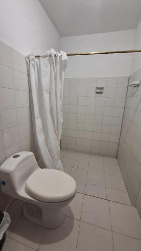 a white bathroom with a toilet and a shower at Casa Tortuga in El Valle