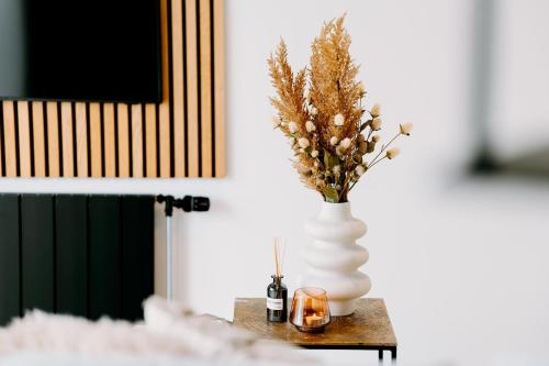 a white vase with flowers and candles on a table at Lake House 10 - 4 Person Lake view Apartment! in Offingawier