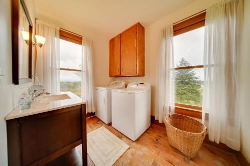 Un baño con dos lavadoras y un lavabo y ventanas. en Historic Victorian Farmhouse with Porch and Views!, en Mayville
