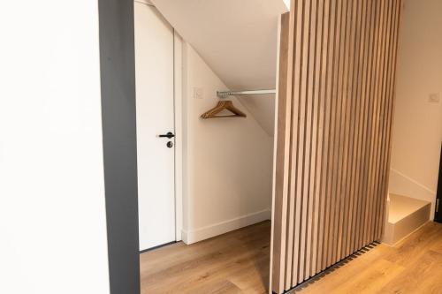 a hallway with a wooden door and a stair case at Maison contemporaine Plescop in Plescop
