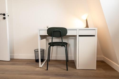 a black chair sitting at a white desk at Maison contemporaine Plescop in Plescop