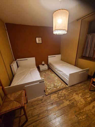 une chambre avec deux lits et un lustre dans l'établissement Chez nina, à Saint-Éloi