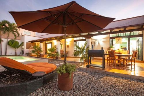 a backyard with a pool and an umbrella at private Pool, walk to malecón, 2 BR estilo hacienda in La Paz
