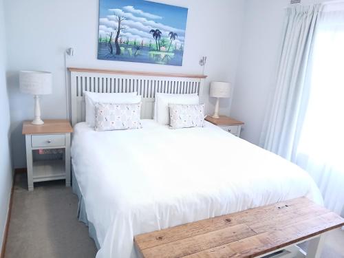 a bedroom with a bed with white sheets and pillows at Hope at Mangaliso in Hilton