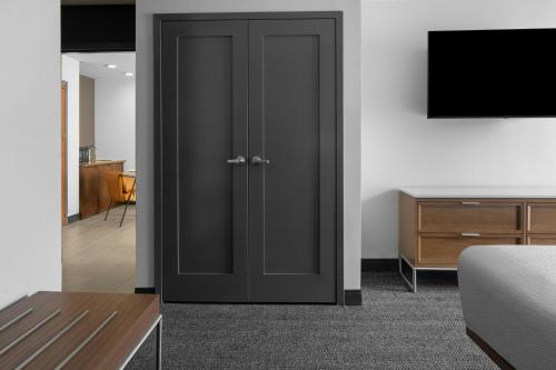 a black door in a room with a television at Courtyard San Jose Airport in San Jose