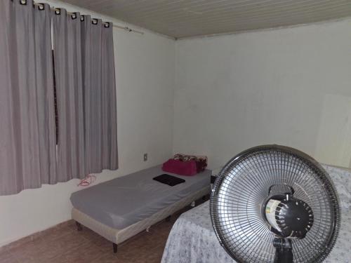 a room with a bed and a fan at Casa Para TECNOSHOW Comigo Rio Verde GO in Rio Verde