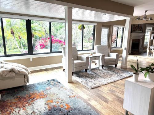 a living room with chairs and a table and windows at Sarasota Charm in Sarasota