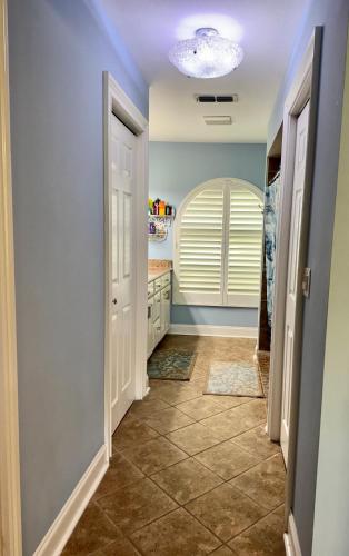 a hallway of a home with blue walls and tile floors at Sarasota Charm in Sarasota