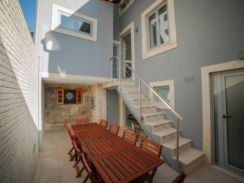a staircase in a house with a wooden table and chairs at OPORTO GUEST - Maia House in Porto