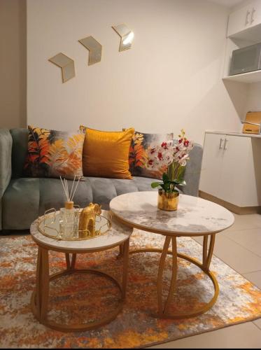 a living room with two tables and a couch at Cozy Mellenial Umhlanga studio in Durban