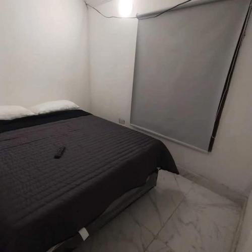 a bedroom with a bed in a white room at Casa CNH 2 in Santiago del Estero