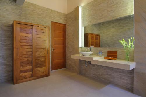 a bathroom with a sink and a mirror at Bali Nyuh Gading Villas in Seminyak