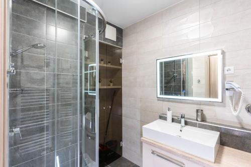 un bagno con doccia, lavandino e specchio di Sunset Resort 505 a Fonyód