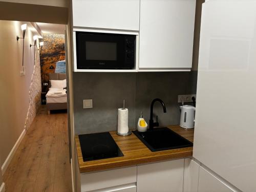a small kitchen with a sink and a microwave at PROVENIR HOME KWIATOWA 5 in Poznań