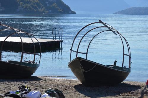 two boats sitting on a beach near the water at Bellavista Home with pool & lakeview in Plesio