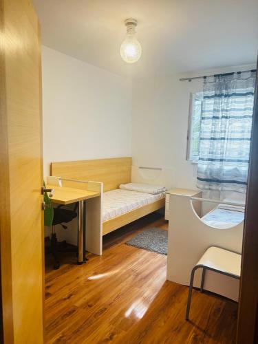 ein kleines Zimmer mit einem Bett und einem Schreibtisch in der Unterkunft Apartman Lana in Stobreč