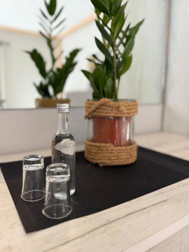 two glasses and a bottle on a black napkin at Dom Suites in Aghii Apostoli