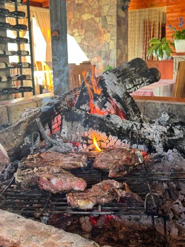 a grill with meat on it with a fire at VILA DISHA in Tirana