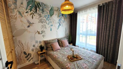 a bedroom with a bed with pink pillows at Apartament Nowoczesny Fordon in Bydgoszcz