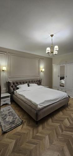 a bedroom with a large bed and a chandelier at Sonne by BED-Stage in Braşov