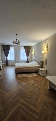 a large bedroom with a bed and a wooden floor at Sonne by BED-Stage in Braşov
