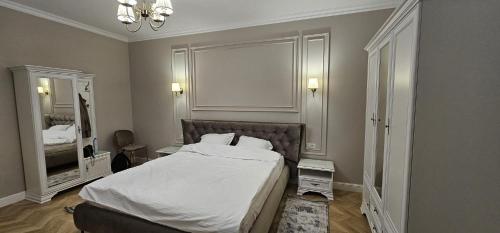 a bedroom with a large bed and a mirror at Sonne by BED-Stage in Braşov