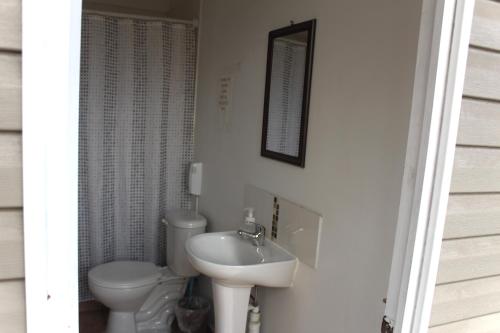 a white bathroom with a toilet and a sink at Aerohostal in Santiago
