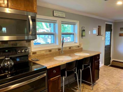 a kitchen with two sinks and a stove at Quaint Cottage - Kansas City Area in Kansas City