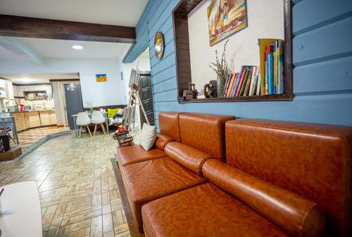 a brown leather couch in a living room at Захарова Оселя БАСЕЙН на території є Чан - Джакузі in Slavske