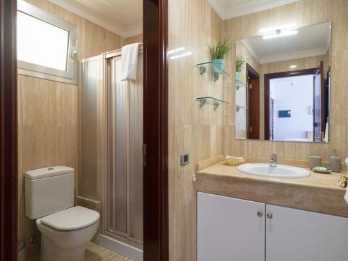 a bathroom with a toilet and a sink and a mirror at HolaMogamar in Puerto de Mogán