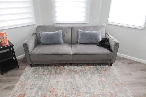 a couch with two pillows in a living room at 3Bed 2Bath Apt Near NYC plus Parking and Laundry in Irvington