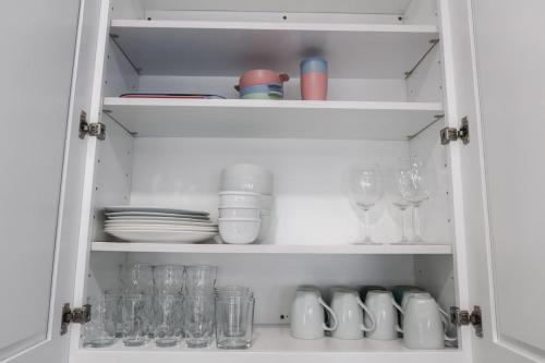 a cupboard filled with glasses and plates and dishes at 3Bed 2Bath Apt Near NYC plus Parking and Laundry in Irvington