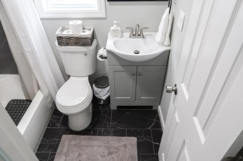 a small bathroom with a toilet and a sink at 3Bed 2Bath Apt Near NYC plus Parking and Laundry in Irvington