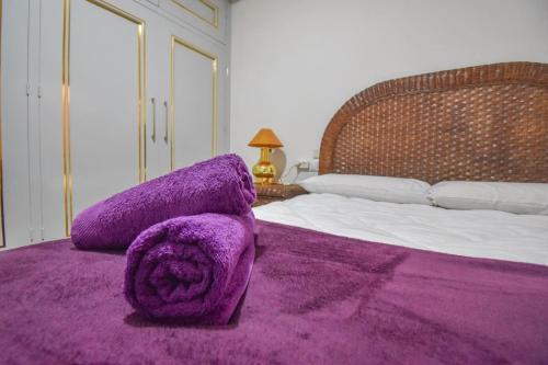 a bedroom with a purple blanket on a bed at Sweetstaybykw Dean Llopez Stay in Santa Pola