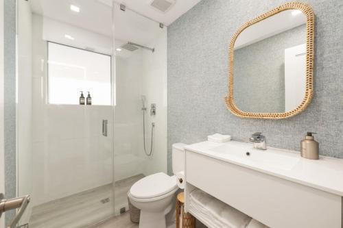 Un baño con inodoro, lavabo y espejo. en Lux Designer Apt 2BR and 2BA in Heart of Miami Beach, en Miami Beach