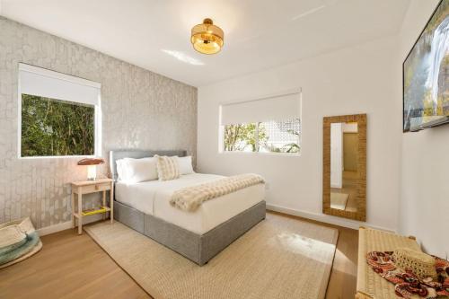 a bedroom with a bed and a mirror at Lux Designer Apt 2BR and 2BA in the Heart of MIA Beach in Miami Beach