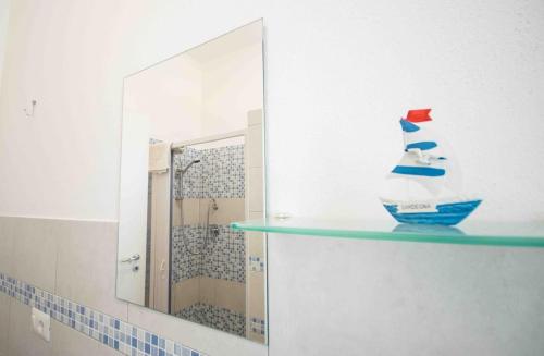 a bathroom with a mirror and a shelf with a fish bowl at Casa Verde Mare in La Caletta