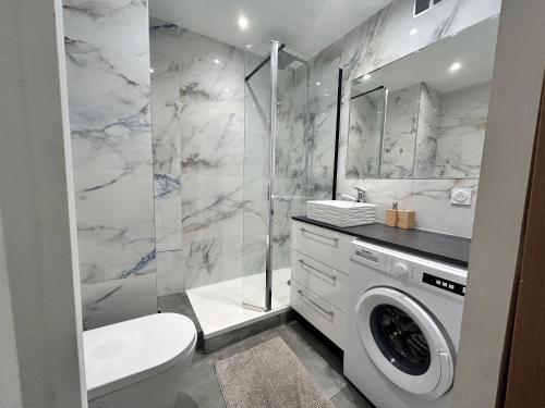 La salle de bains est pourvue de toilettes et d'un lave-linge. dans l'établissement L'écrin - 4 pers - Neuf - Hyper centre - Plage à 2 min à pied, à Saint-Raphaël