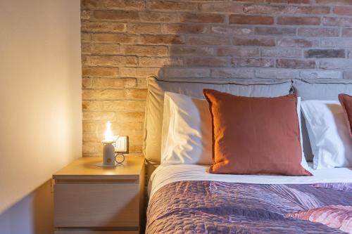 a bedroom with a bed and a brick wall at Mansarda open space in Cento
