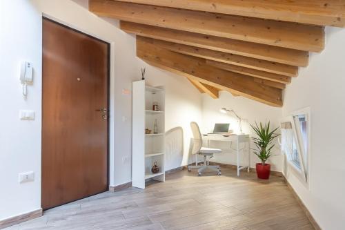 an attic office with a desk and a wooden ceiling at Mansarda open space in Cento