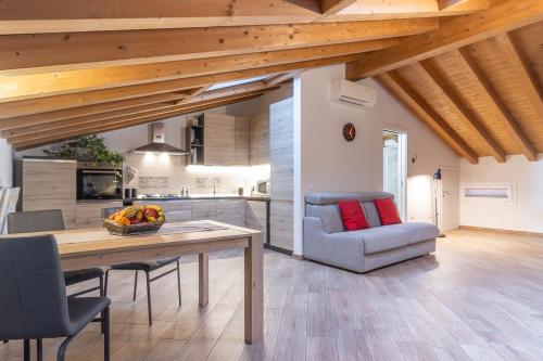 a kitchen and living room with a table and a couch at Mansarda open space in Cento