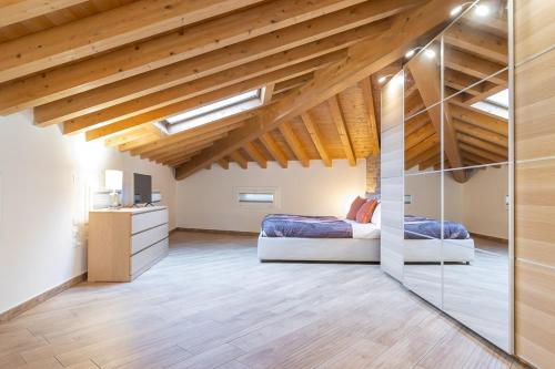 a bedroom with two beds in a loft with wooden ceilings at Mansarda open space in Cento